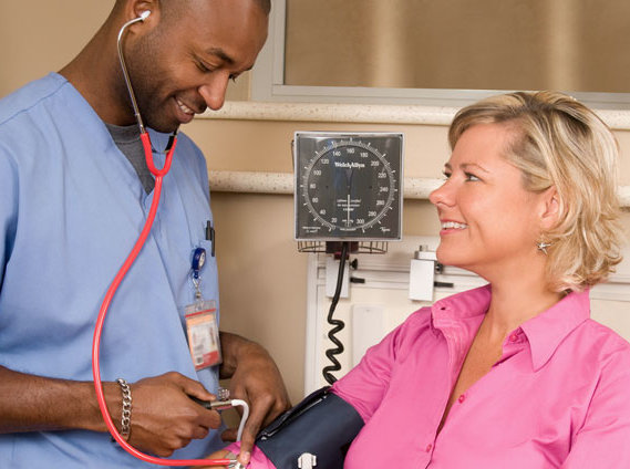 Woman getting her blood pressure taken by a nurse