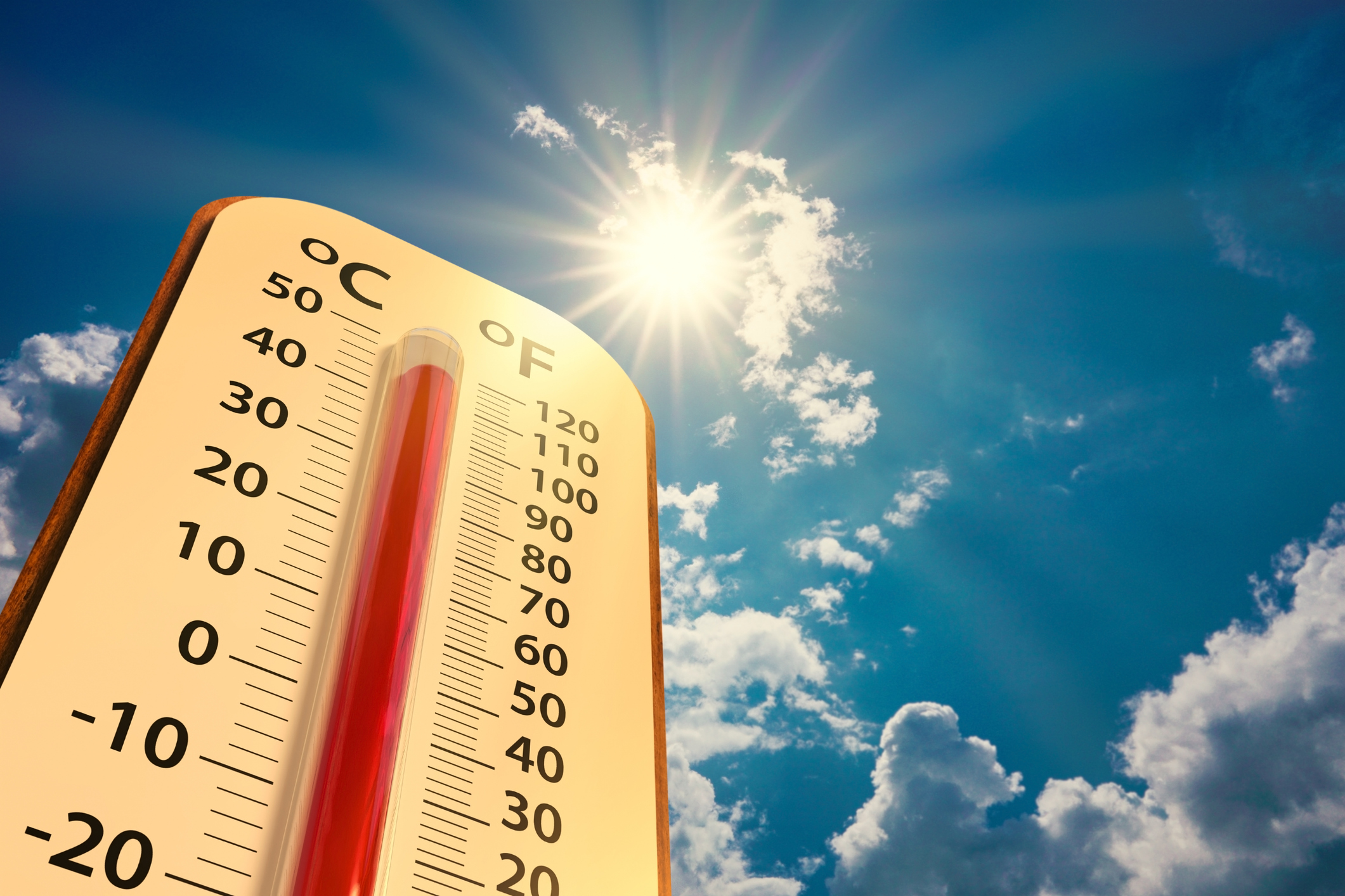 low angle view Thermometer on blue sky with sun shining